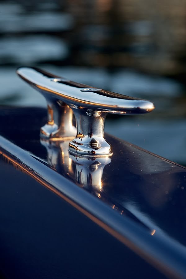 A single stainless steel cleat, polished, golden hour